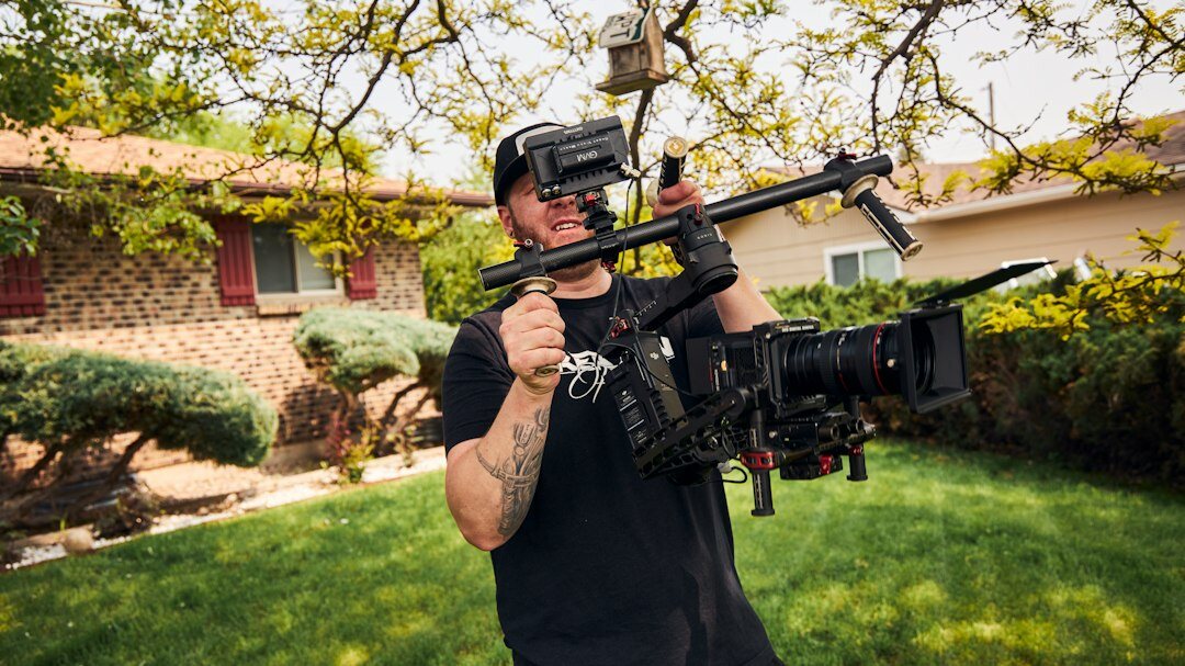Camera operator filming with a professional broadcast camera in a studio